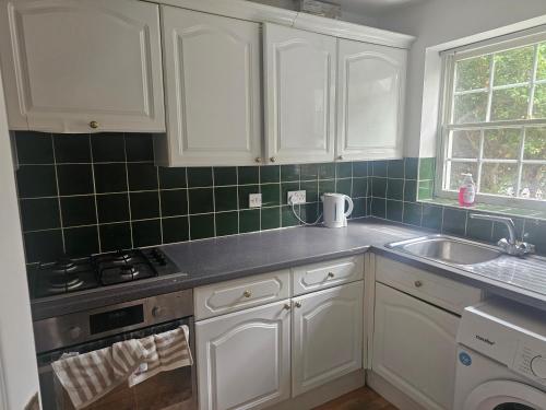 a kitchen with white cabinets and a sink at Ramsgate Cozy Home in Ramsgate