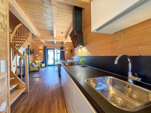 a kitchen with a stainless steel sink and wooden walls at Rattendorf 20A in Rattendorf