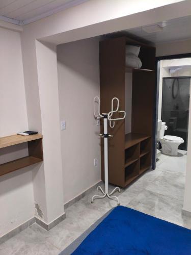 a room with a bathroom with a blue rug at Recanto Coração da Ametista - Apart hotel & Suítes in Ametista do Sul