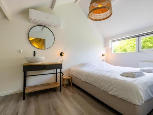 a bedroom with a bed and a sink and a mirror at De Nordic Escape in Warmenhuizen