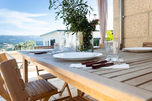 a wooden table with a plate and a vase on it at Quinta do Olival Amarante in Gatão