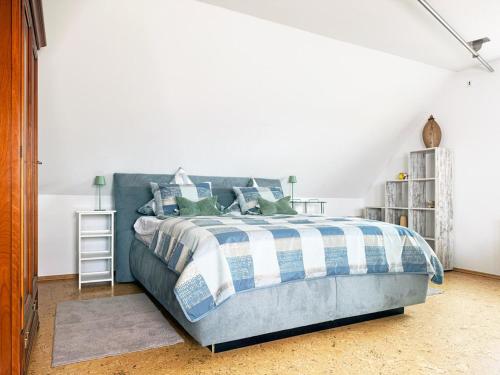 a bedroom with a bed with a blue and white comforter at Am Berg und See in Stemwede