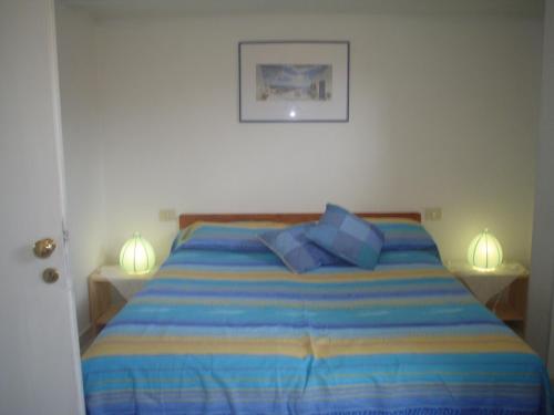 a bed with two pillows on it in a bedroom at Villetta Lucia in Sperlonga