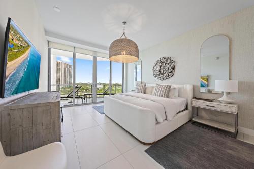 a living room with a white couch and a tv at Amrit Resort - Bask in Rare Oceanfront Luxury with Stunning Views in Riviera Beach
