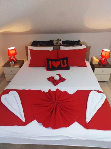 a bedroom with a bed with red and white bedding at Park Apartment in Kočani