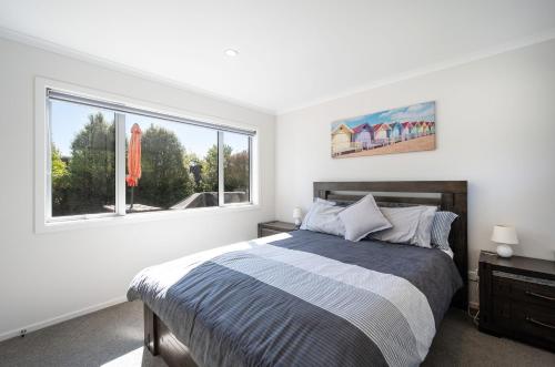 a white bedroom with a bed and a window at Pohara Retreat in Pohara