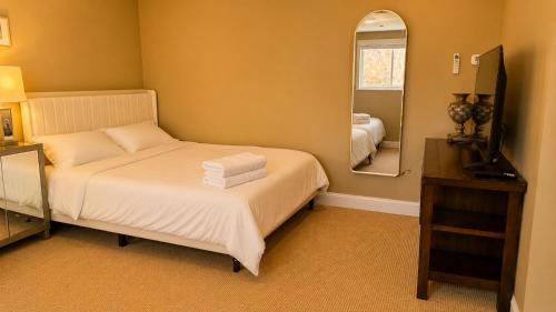 a small bedroom with a bed and a mirror at Private Two Queen Beds Room Near UPEI & Downtown Cozy Retreat Near Everything in Charlottetown