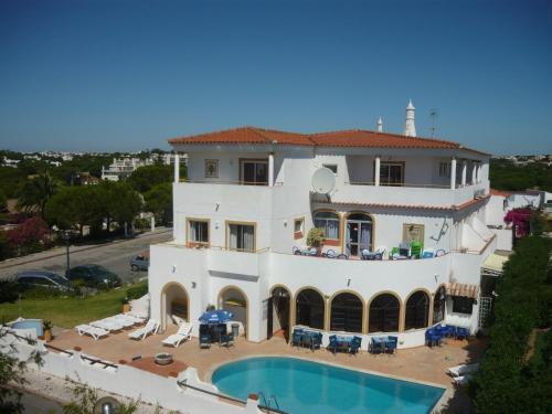 uma vista aérea de uma grande casa branca com uma piscina em Agua Marinha ROSA- Hotel em Albufeira