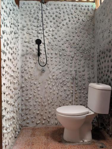 a bathroom with a toilet and a shower at Fadhila Cottages Togean Dive Resort in Katupa
