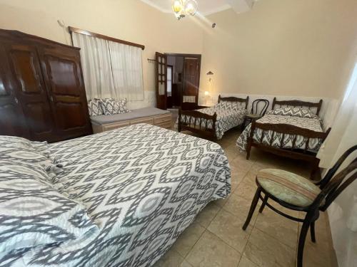 a bedroom with two beds and a couch and a chair at CASA NONI in Salta