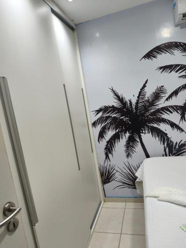 a bedroom with a palm tree mural on the wall at Flat Aconchego Olinda - Vista e Piscina in Olinda