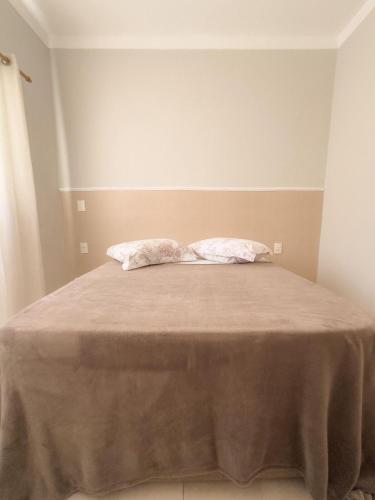 a bed with two pillows on it in a room at Casa Doce Lar 2 in Uberaba
