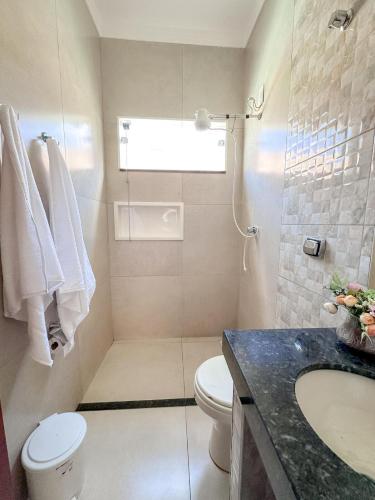 a bathroom with a toilet and a sink at Casa Doce Lar 2 in Uberaba