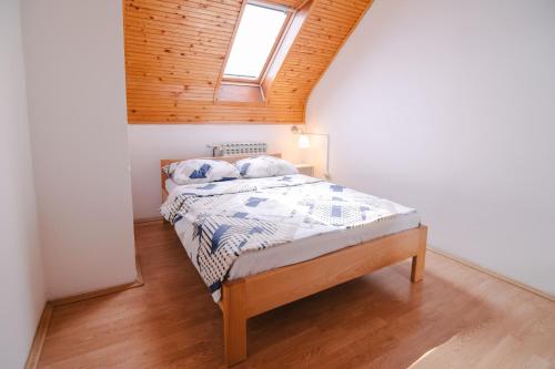 a bedroom with a bed with a wooden ceiling at Apartment Smoljanac 14979a in Smoljanac