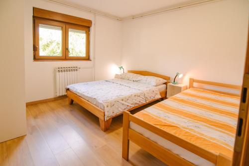 a bedroom with two beds and a window at Apartment Smoljanac 14979b in Smoljanac