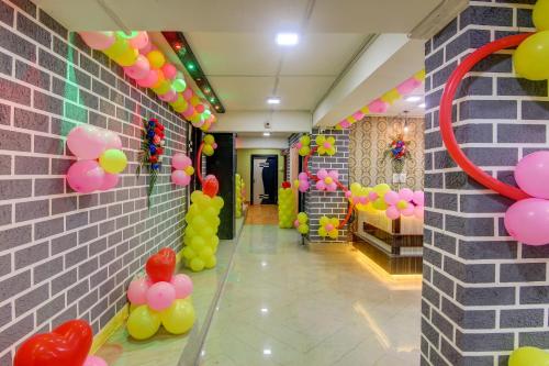 a hallway with balloons and a wall with a mirror at Capital O Divira Inn in Dhanbād