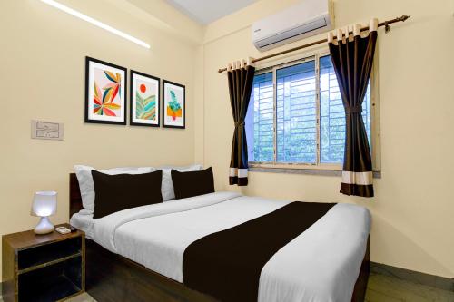 a bedroom with a large bed and a window at Super Collection O Gariahat Kolkata Formerly 6 Seasons in Kolkata