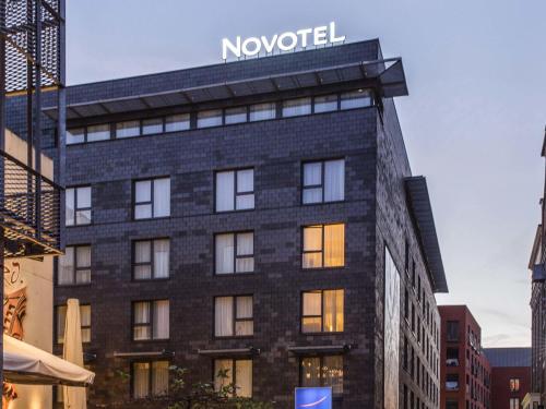 a building with a sign on top of it at Novotel Mechelen Centrum in Mechelen