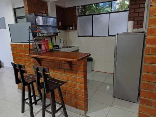 a kitchen with a brick wall and a bar with stools at Munay Wasy Carhuaz in Carhuaz