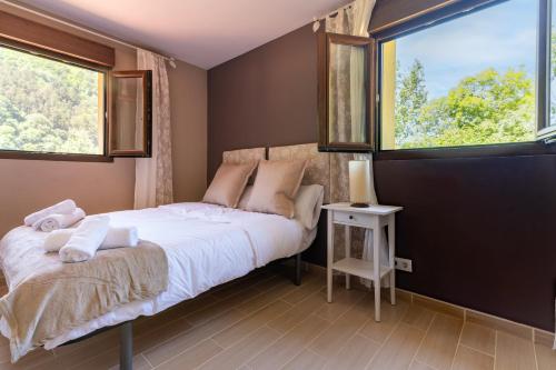 a bedroom with a bed and two windows at NorthStyle by Fidalsa in Lanestosa
