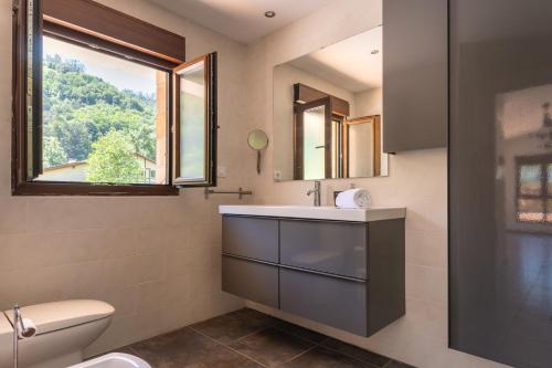 a bathroom with a sink and a toilet and a window at NorthStyle by Fidalsa in Lanestosa