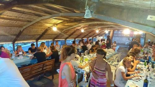 a group of people sitting at tables in a restaurant at Elba Residence in Capoliveri
