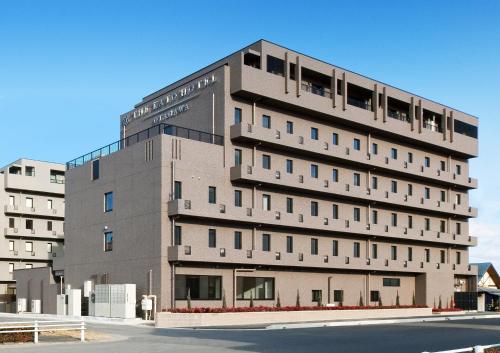 a tall gray building on a city street at The Kato Hotel in Tokai