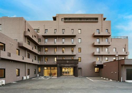 a large brown building with a parking lot at The Kato Hotel in Tokai