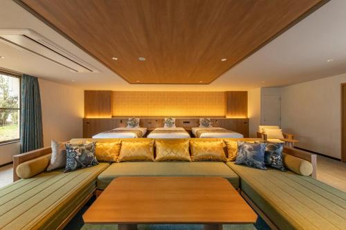 a large room with a couch and two beds at Spa Resort Hawaiians Hotel Hawaiians in Iwaki