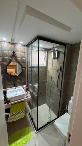 a bathroom with a glass shower and a sink at Horto da Barra - Apartamento à Beira Mar in Barra dos Coqueiros