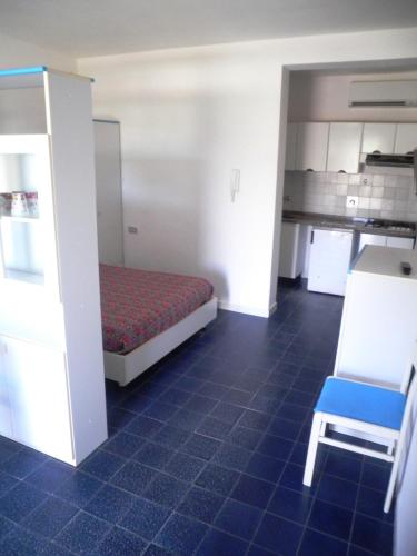 a room with a bed and a chair and a kitchen at Elba Residence in Capoliveri