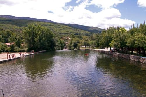 a river with people walking on the side of it at Apartamentos Dacris in Jerte