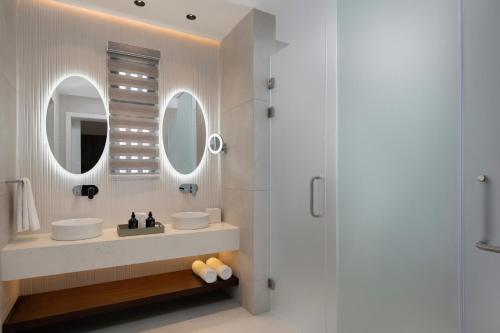 a bathroom with two sinks and a shower at Donoma Las Terrenas Resort & Villas, Autograph Collection in Las Terrenas