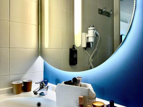 a bathroom with a sink and a large mirror at Ibis Budget Madrid Alcorcón Móstoles in Alcorcón