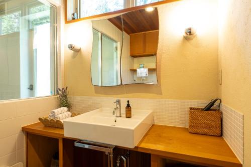 a bathroom with a white sink and a mirror at CALL92Chalet in Hakuba