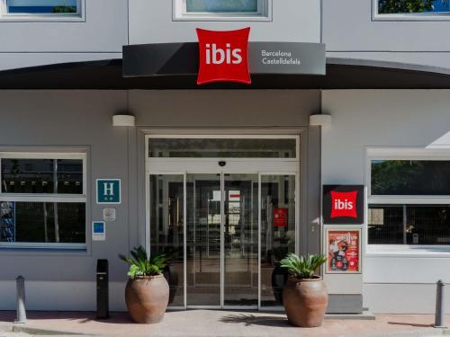 a ups store with two potted plants in front of it at Ibis Barcelona Castelldefels in Castelldefels