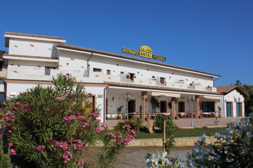 a white building with a sign on top of it at La Perla Hotel in SantʼAnna Arresi