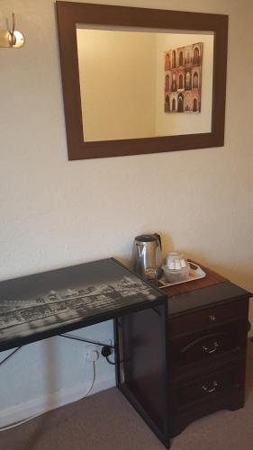 a desk in a hotel room with a coffee maker on it at Maindee Guest House in Barrow in Furness