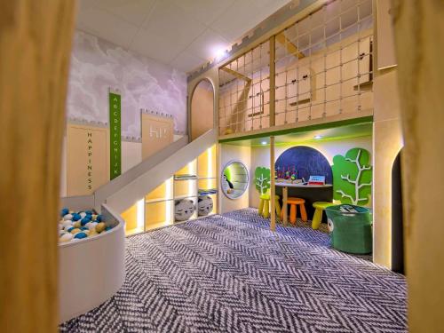 a childrens room with a staircase and a table at Novotel Kraków Centrum in Krakow