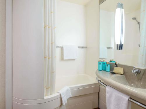 a bathroom with a tub and a sink and a shower at Novotel Torino Corso Giulio Cesare in Turin