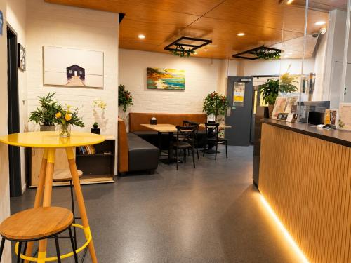 ein Restaurant mit Theke, Tisch und Stühlen in der Unterkunft Gamma Hotel in Auckland