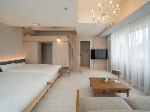 a bedroom with a large bed and a living room at ホテル寺町亘hotel teramachi watari in Matsue