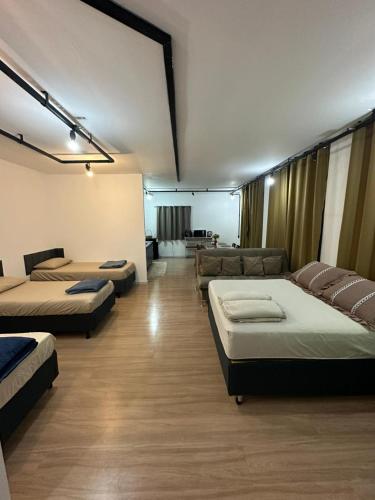 a room with three beds and a couch at Kitnets do Supermercado Simples Luxo e Deluxe! in Limeira