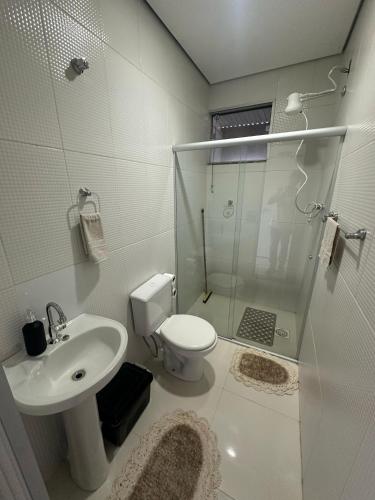 a bathroom with a shower and a toilet and a sink at Kitnets do Supermercado Simples Luxo e Deluxe! in Limeira