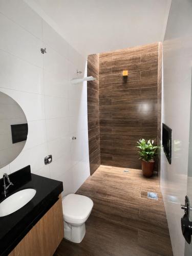 a bathroom with a toilet and a sink at Conforto e praticidade em um só local in Rio Verde