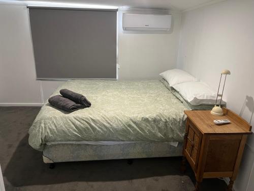 a small bedroom with a bed and a night stand at Mimis Cottage in Cohuna