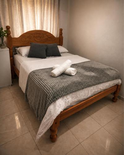 a bedroom with a bed with a wooden head board at Caliani Hotel in Espigão dʼOeste