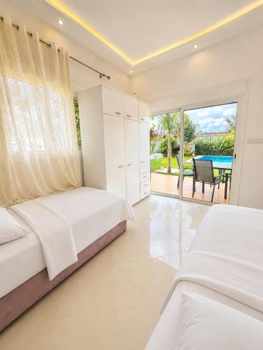 a bedroom with two beds and a view of a patio at Luxury Villa with Pool & Garden5km from Cabo in Tétouan