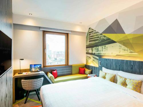 a bedroom with a bed and a desk and a window at Ibis Styles Ambassador Seoul Gangnam in Seoul