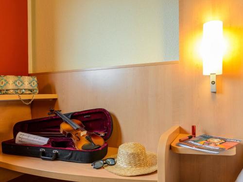 a violin sitting inside of a suitcase on a table at Hotel Ibis Milano Malpensa in Cardano al Campo